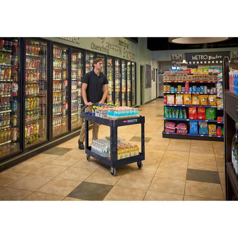Employee using Two Shelf Foam Utility Cart With Lipped Shelves And Ergonomic Handle Black 500 Lb Capacity Durable Rolling Cart in store