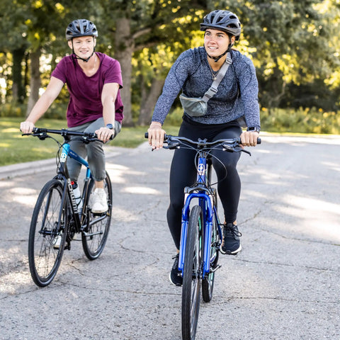 Two people riding GTX 2 Hybrid Bike For Men And Women With 700C Wheels 21 Speed Gearing Aluminum Dual Sport Frame