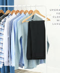 Wooden Coat Hangers 30 Pack Natural Wood Heavy Duty Non Slip For Shirts Jackets Pants Suits With Chrome Swivel Hook Premium Solid Closet Hangers For Easy Organizing, displayed with shirts and a pair of pants on a clothing rack.