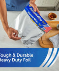 Person using Heavy Duty Aluminum Foil Roll Beefy Strength 12 Inch Wide 50 Square Feet With Secure Easy Open Tab in kitchen.
