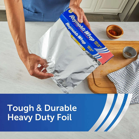 Person using Heavy Duty Aluminum Foil Roll Beefy Strength 12 Inch Wide 50 Square Feet With Secure Easy Open Tab in kitchen.