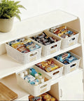 Six Pack Stackable Plastic Storage Bins With Lids And Bamboo Lid holding snacks and toiletries on white shelves