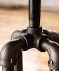 Close-up of a heavy duty half inch street elbow 90 degree pipe fitting in black malleable iron used in DIY furniture