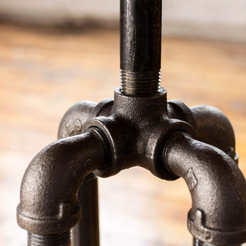 Close-up of a heavy duty half inch street elbow 90 degree pipe fitting in black malleable iron used in DIY furniture