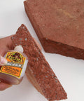 Applying Heavy Duty Waterproof Polyurethane Glue For Wood, Metal, Stone, Ceramic, Glass, And Concrete, 2 Ounce Brown Bottle on brick
