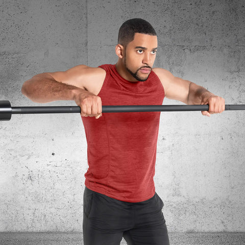 Elite Seven Foot Olympic Weight Bar Built Different With Stainless Spin Sleeves And Aggressive Knurling For Real Deal Lifters Crushing Personal Records And Heavy Squat Sessions being held by a lifter in a gym setup.