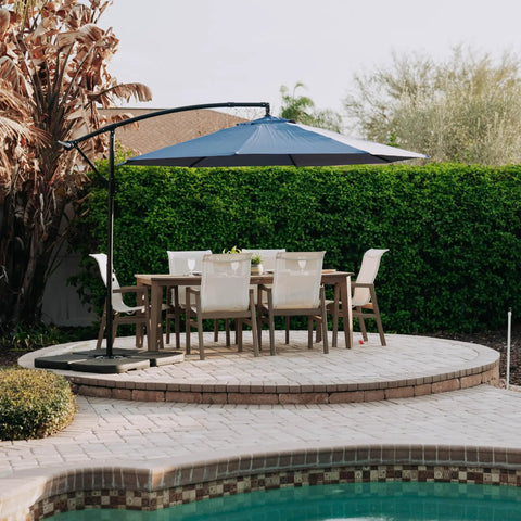 Outdoor setup featuring a cantilever umbrella with Heavy Duty Offset Umbrella Base Weight Set For Cantilever Umbrellas Fill With Water Or Sand.