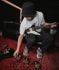 Musician adjusting JCM800 Inspired Overdrive Distortion Guitar Pedal With Gain Sensitivity And Tone Controls Black And Gold Finish