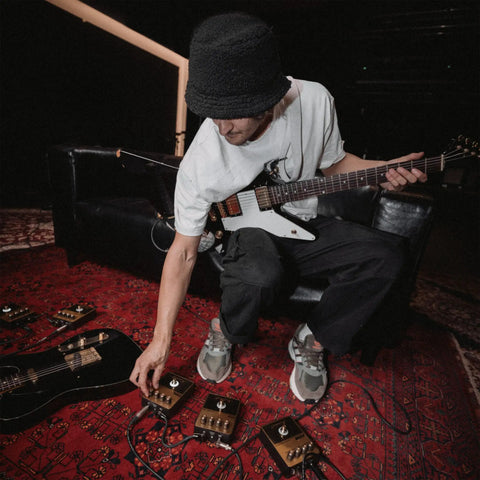 Musician adjusting JCM800 Inspired Overdrive Distortion Guitar Pedal With Gain Sensitivity And Tone Controls Black And Gold Finish