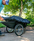 Person covering a Beefy Heavy Duty Utility Cart With 10 Cubic Feet Tub And 400 Pound Load Capacity With Flat Free Wheels outdoors
