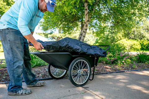 Person covering a Beefy Heavy Duty Utility Cart With 10 Cubic Feet Tub And 400 Pound Load Capacity With Flat Free Wheels outdoors