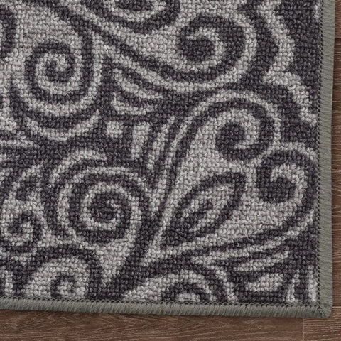 Close-up of floral gray design on non slip stair treads carpet, part of peel and stick set of 13, floor safe for wood tile.