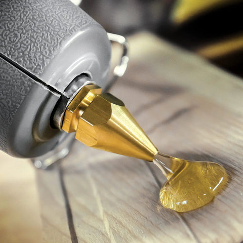 Industrial High Temp Hot Glue Sticks 10 Inch Light Amber for Packaging dispensing onto wood surface, close-up shot