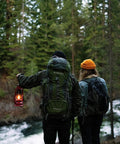 Hikers in forest holding 12 Inch Hurricane Lantern With Durable Red Finish For Camping And Emergencies, classic outdoor gear
