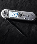 Sizzle Pro Grade Digital Meat Thermometer Instant Read In 2 Seconds Waterproof Folding Probe With Magnetic Back Auto Rotating Backlit Display For Cooking Food Grill And Barbecue Cayenne Pepper Red on a dark surface with water droplets