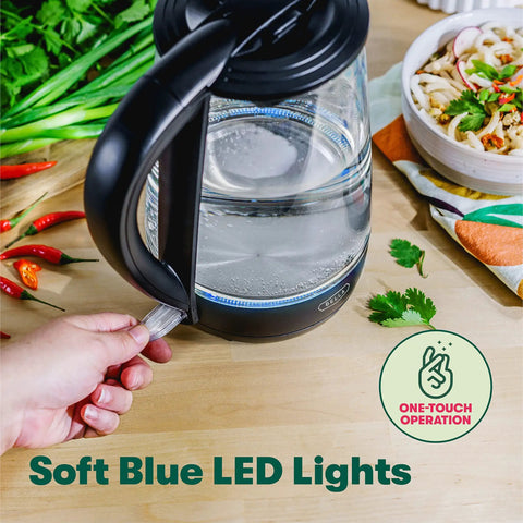 1.7 Liter Glass Electric Kettle That Boils Seven Cups In Just Six To Seven Minutes With Soft Blue LED Lights, Cordless Portable Water Heater, Auto Shut Off, Black Finish on a table with vegetables.