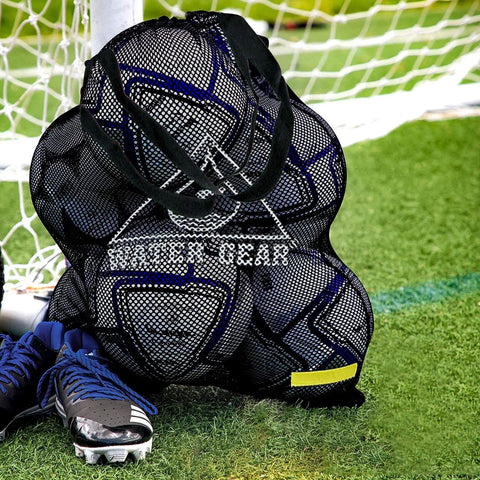 Large Mesh Tote Bag With Zipper For Swim Gear, Balls And Aqua Equipment on grass by soccer goal with sports shoes