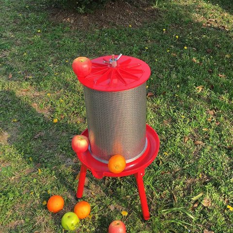 Water-Powered Fruit Wine Press For Home Cider And Natural Juice Making, Electricity-Free Hydraulic Press With 10.7 Gallon Capacity, Includes Filter Bag And Splash Guard, Awesome For Easy DIY Wine, Cider, And Fresh Juice. Outdoor red metal fruit press with apples and oranges