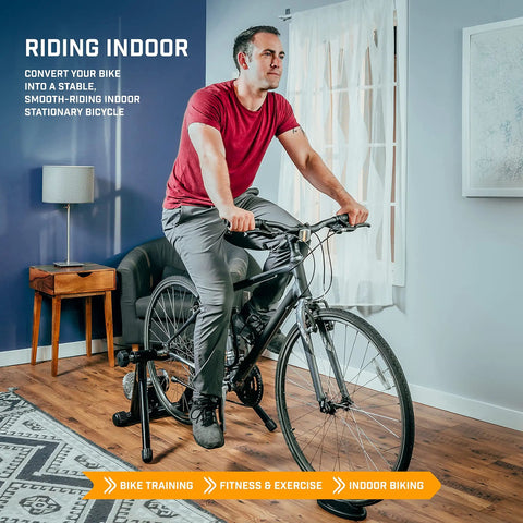 Person using Portable Foldable Fluid Bike Trainer Stand For Indoor Riding With Stainless Steel Frame Near Silent Flywheel