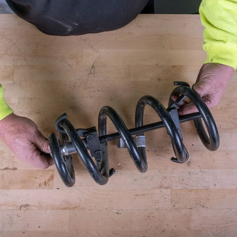 Hands using Coil Spring Compressor Tool For Cars And Trucks Easy Removal And Installation Built In Locking Detent Latches
