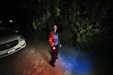 Night scene with police-style red and blue lights illuminating a person, demonstrating outdoor analog CCTV camera two pack with 1080p full HD video and motion detection.
