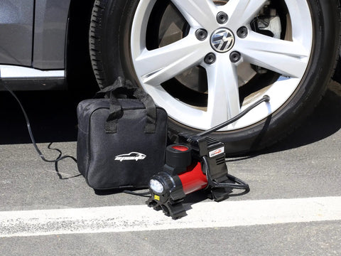 12V DC Portable Air Compressor With Digital Pressure Gauge And Bright Led Light For Cars Bikes And Midsize Suv Heavy Duty Tire Inflator Pump next to a car tire.