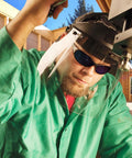 Worker wearing Hellraiser Safety Glasses With Blue Mirror Lenses And Black Frame For Outdoor Work under helmet shield