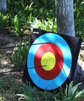 Backyard Archery Target in 20x20x2 Inch High Density EVA Foam leaning against a tree with arrows in a colorful bullseye.