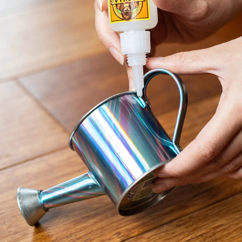 Applying Clear Gel Super Glue For All Purpose Bonding Fast Setting And No Run Formula Great For Glass Plastic Wood Ceramic And More Ideal For DIY Projects And Household Repairs 20 Gram Pack to a metal watering can.