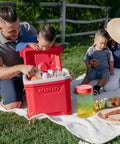 Family enjoying picnic with Profile II 16 Quart Red Cooler With Fold Flat Bail Handle, Cool Riser Technology For Superior Cooling.