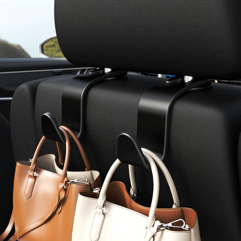 Black S-type car seat headrest hooks mounted on the seat back, holding handbags.