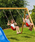 Two children on a swing set using the Beefy 10000 Lb Heavy Duty Swing Hanger Set For Indoor Outdoor Swing Sets Pack Of Four Green Weatherproof.