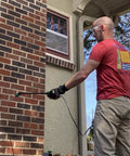 Man applying Penetrating Siloxane PD Weather Seal For Concrete, Masonry, Stucco And Manufactured Stone Breathable Water Resistant Shield That Stops Cracking, Spalling, And Stains With 10 Year Service Life, 1 Gallon to brick wall