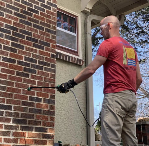 Man applying Penetrating Siloxane PD Weather Seal For Concrete, Masonry, Stucco And Manufactured Stone Breathable Water Resistant Shield That Stops Cracking, Spalling, And Stains With 10 Year Service Life, 1 Gallon to brick wall