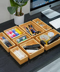 Bamboo Drawer Organizer Set Of 9 For Kitchen And Office, Crushes Junk Drawer Chaos While Keeping Cutlery Silverware Utensils Makeup And Desk Supplies Neatly Sorted In Bathrooms And More displayed on a desk with office supplies inside.