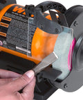 User sharpening a tool on the Heavy Duty 6 Inch Bench Grinder Rig With Rock Solid Cast Iron Stand And Handy Water Pot Tray For Tough Metalwork And Quick Tool Sharpening Chores.
