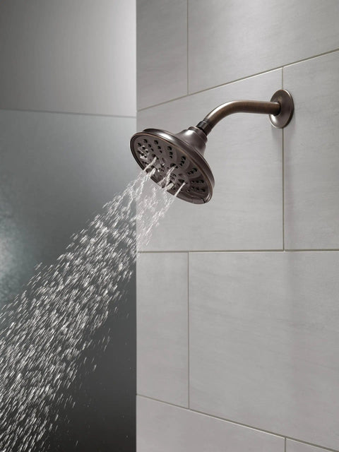 Five Setting Raincan Shower Head With H2Okinetic Spray in Venetian Bronze mounted on a tiled wall with water flowing