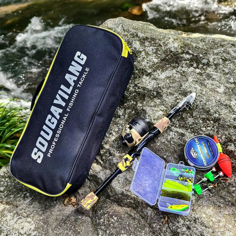 Kids Fishing Rod And Reel Combo Lightweight Telescopic Pole With Spincast Reel, tackle bag and lures on rock by river