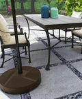 Heavy Duty Patio Umbrella Base Holder Built To Last For Outdoor Use Fillable Up To 66lbs With Stand Or 55lbs With Water Universal Pole Fit 1.4 1.5 Or 1.9 Inch Holds Umbrellas Up To 9.8 Feet Two Adjustable Knobs Brown supporting table umbrella on patio