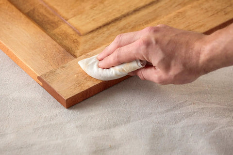 Applying Color Matched Wood Filler In Golden Oak No Sand Ready To Use 6 Oz to wood surface with cloth for seamless repair