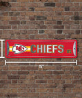 Official Kansas City Chiefs NFL Aluminum Metal Street Sign 4X15 Inch Durable Weatherproof All Indoor And Outdoor Wall Art Decor For Man Cave showcasing red design on a brick wall.