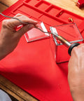 Hands using Power Grip Variable Wattage Soldering Station 20 To 80W With Built-In Safety Rest for electronics on red mat.