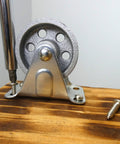 Installed 2-Inch Cast Iron Rigid Plate Caster With 1-1/4-Inch Wide And 2-Inch Diameter Silver Wheel on wooden surface
