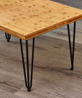 Hairpin Metal Table Legs 20 Inch Set of 4 With Black Screws And Adjustable Cushion Floor Protectors For DIY Furniture Coffee Table Bench Dining End Table Industrial Mid Century Modern Style supporting a wooden table top.