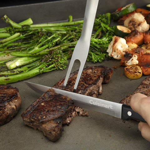 Chef slicing steak on flat top grill with 24 Piece Griddle Tool Set With Storage Tote Stainless Steel Flat Top Grill Accessories