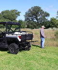 40 Gallon UTV Broadcast Sprayer with 2.2 GPM Diaphragm Pump used by man in field for lawn, farm, and turf care