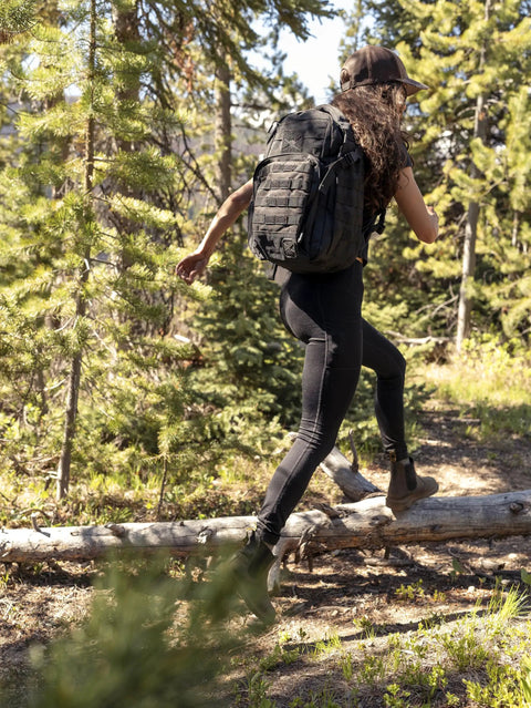 Person hiking with Wakizashi Tactical Backpack 24L With MOLLE System Durable 100 Percent Polyester Gear Pack in forest