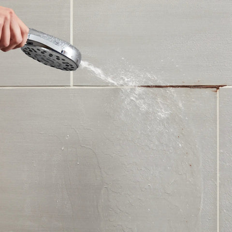 High Pressure Handheld Shower Head With Built In Power Jet And Multiple Spray Settings for cleaning tiles in a bathroom.