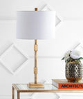 Gold Leaf 29-Inch Geometric Column LED Table Lamp With White Linen Drum Shade, placed on glass table in living room setting.