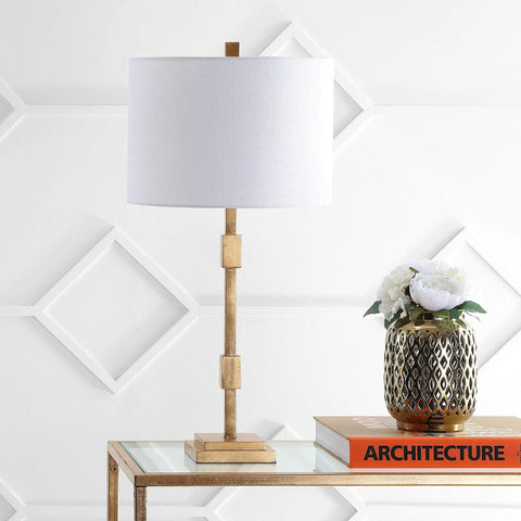 Gold Leaf 29-Inch Geometric Column LED Table Lamp With White Linen Drum Shade, placed on glass table in living room setting.